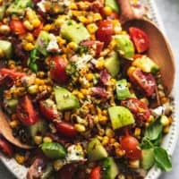 corn salad with wooden serving spoons on a platter