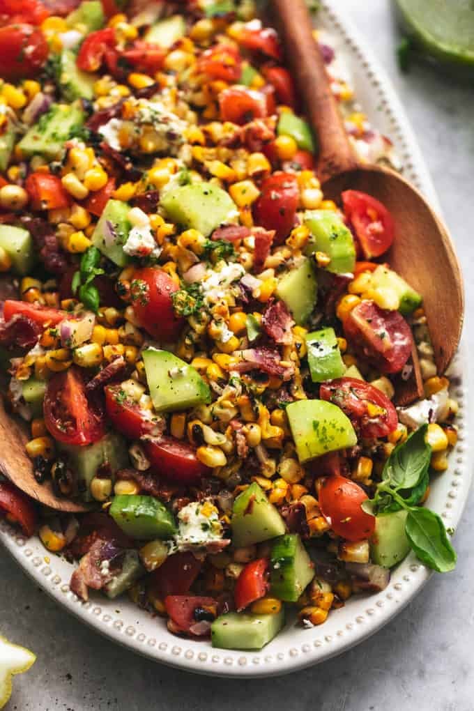 corn salad with wooden serving spoons on a platter