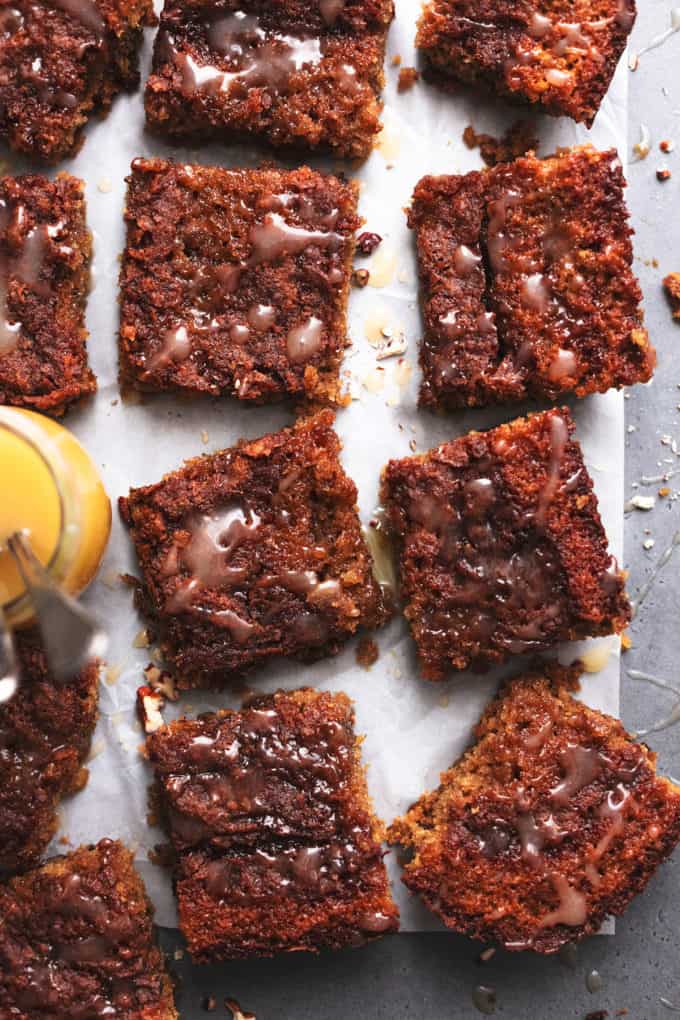 oatmeal cake slices on parchment paper with jar of vanilla sauce