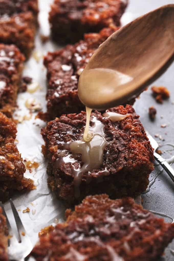 wooden spoon drizzling sauce onto piece of cake