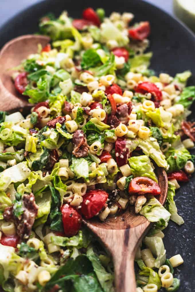 chopped salad with house salad with wooden spoons