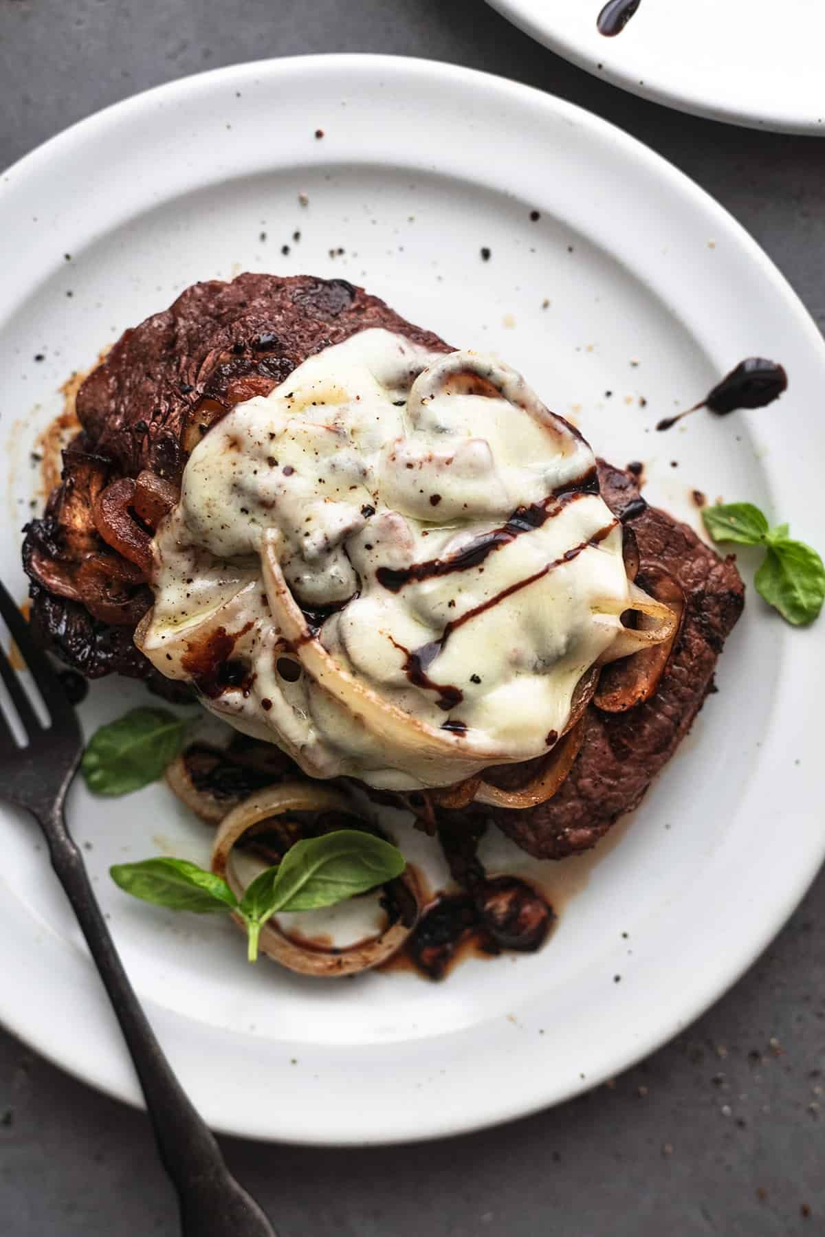 smothered steak with mushrooms and onions on plate