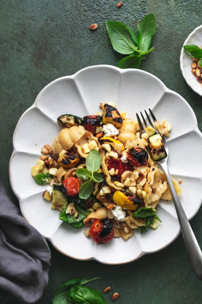 plate of pasta with grilled vegetables and napkin on table