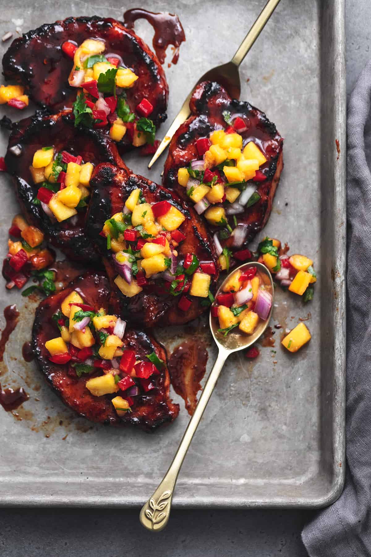 Glazed Pork Chops with Peach Salsa Glazed pork chops with peach salsa on top in a baking sheet.