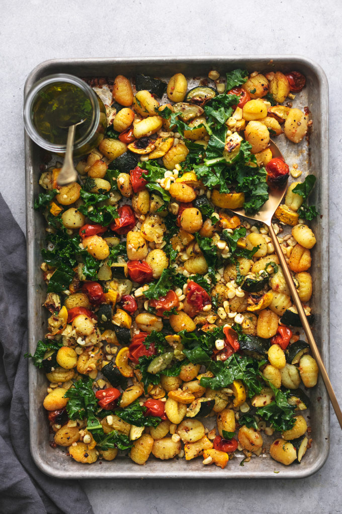 sheet pan gnocchi with serving spoon and dressing in jar