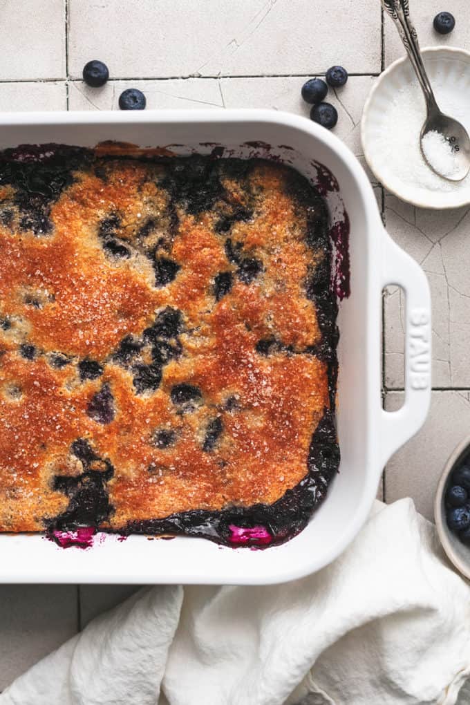 blueberry cobbler in a baking dish with prep items on side