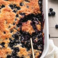 serving spoon scooping blueberry cobbler