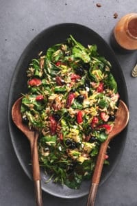 berry orzo salad with wooden serving spoons on platter