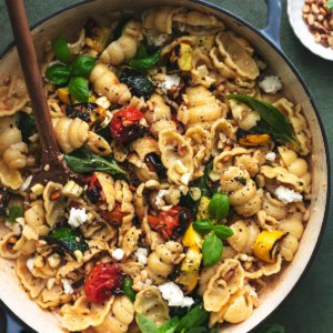 skillet full of pasta noodles with tomatoes and zucchini and corn