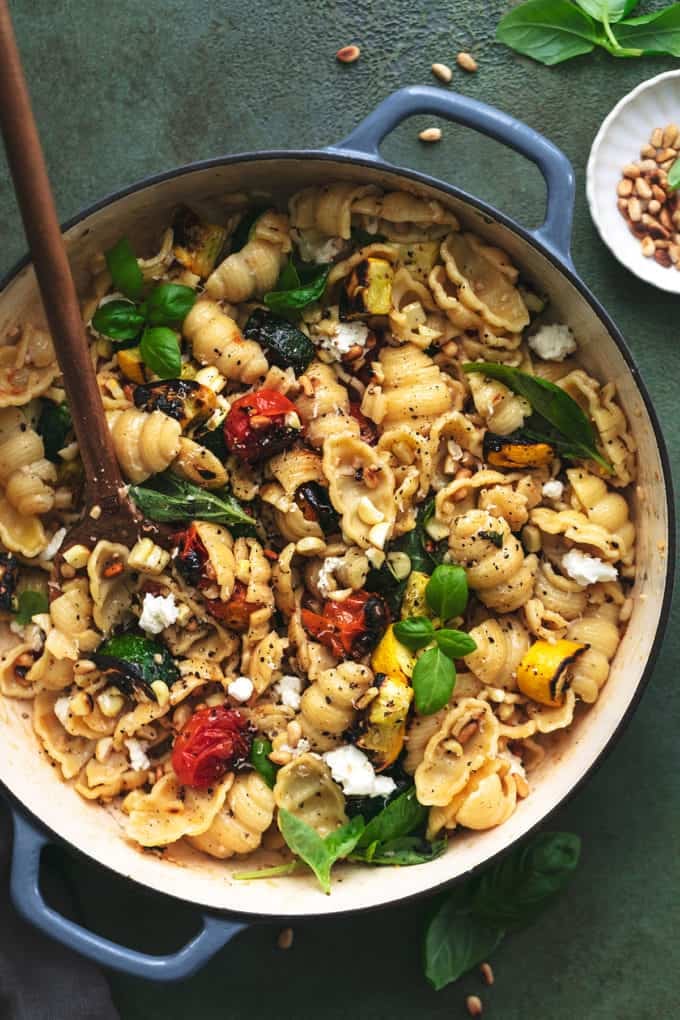 skillet full of pasta noodles with tomatoes and zucchini and corn