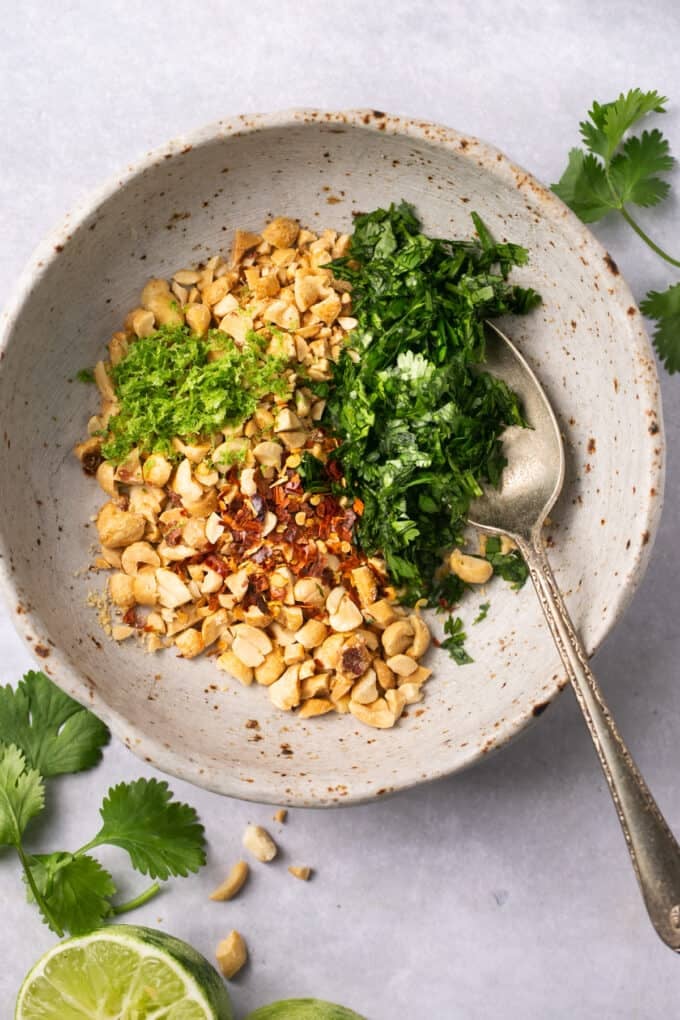 peanuts with cilantro and red pepper flakes in a bowl