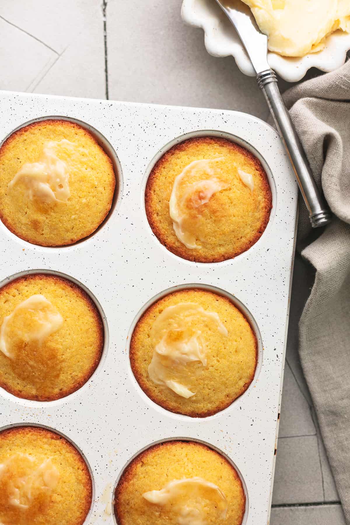 muffins in muffin tin with butter dish 