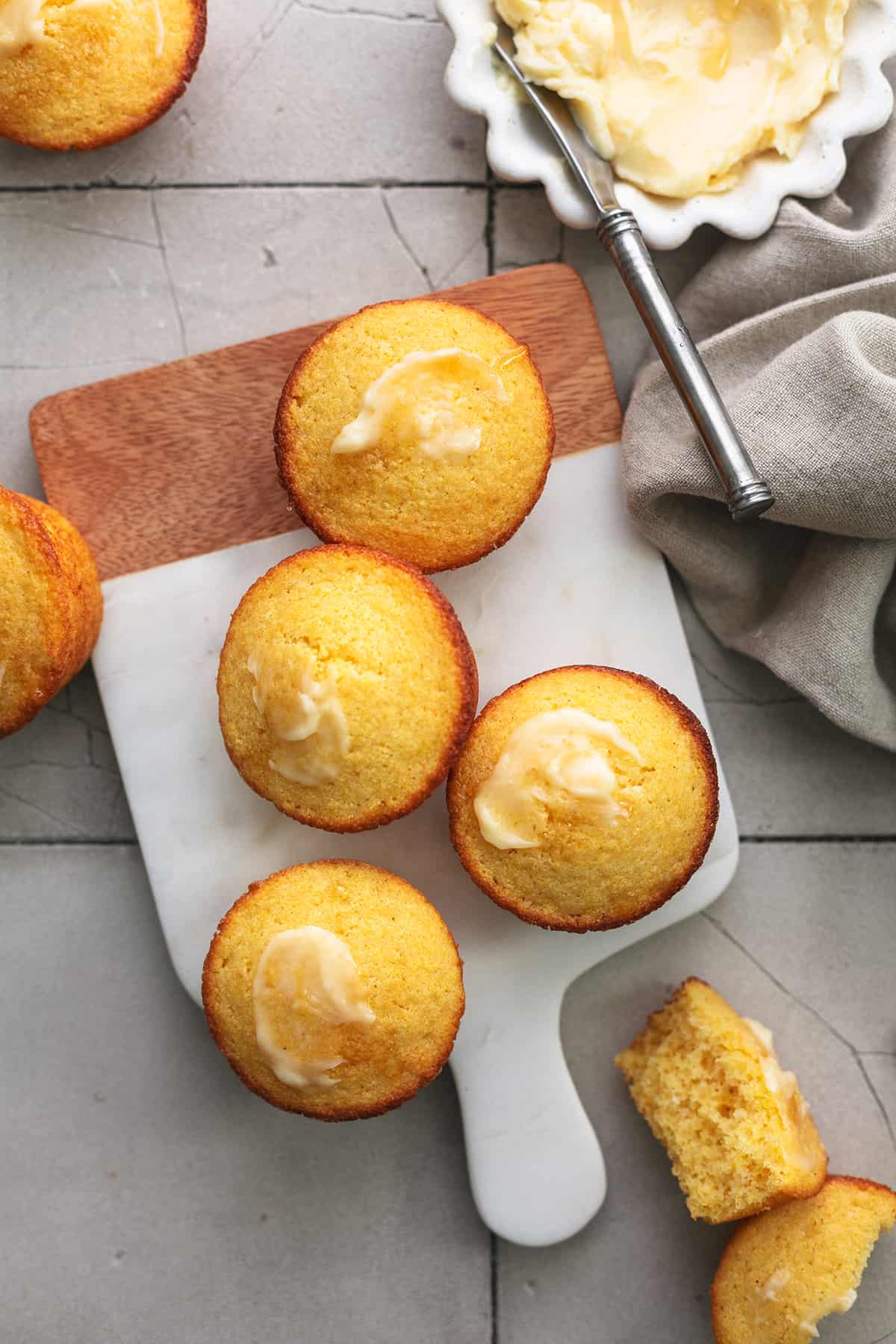 muffins on a cutting board with honey butter in a dish