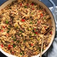 skillet full of rice with ground meat and serving spoon