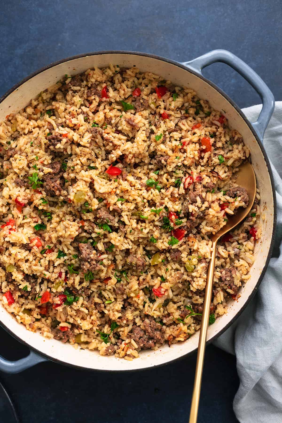 skillet full of rice with ground meat and serving spoon