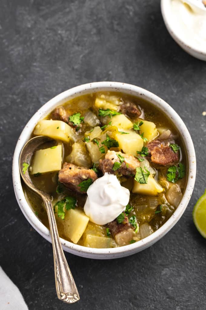 green chile stew with pork and sour cream in bowl