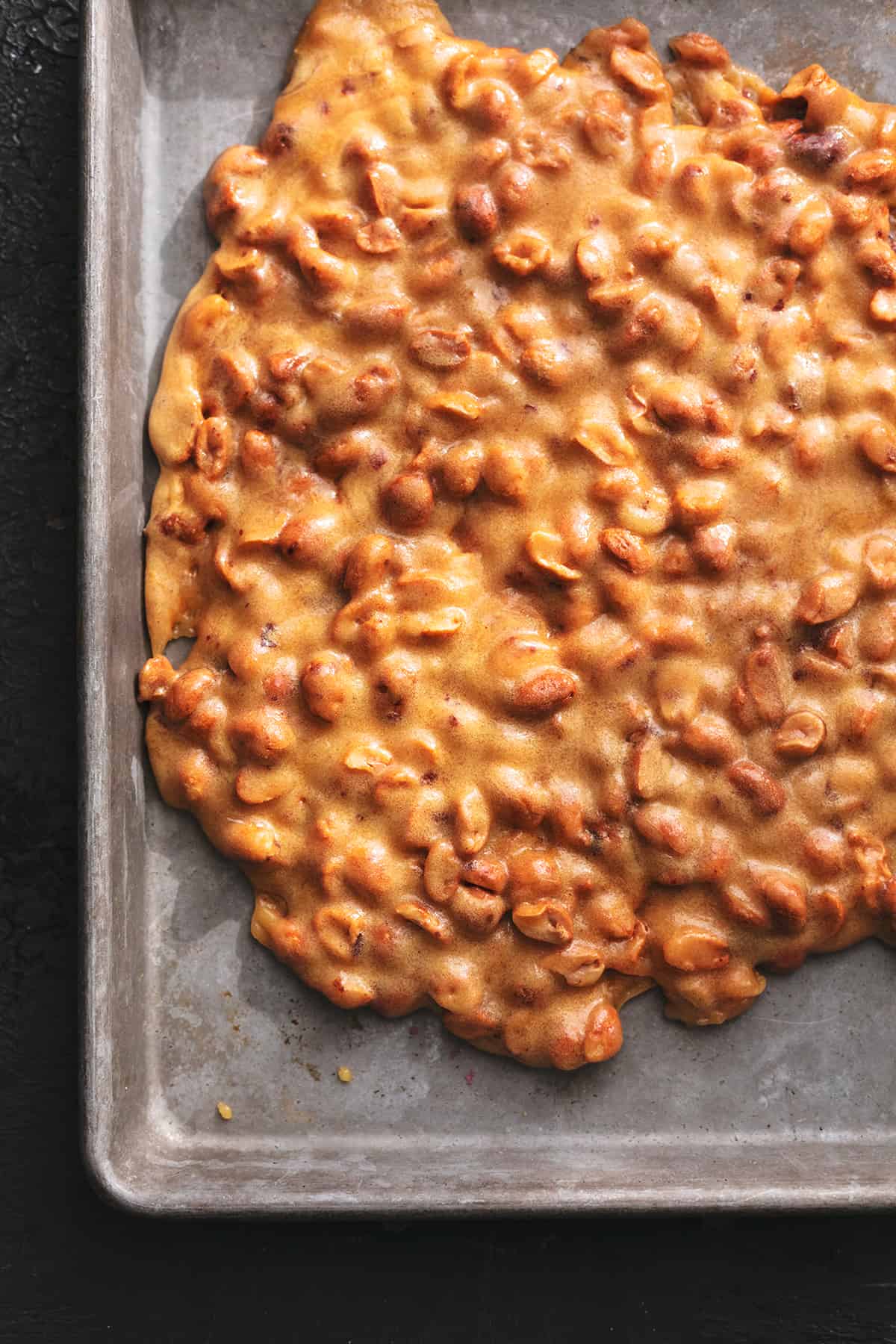 peanut brittle candy cooling on sheet pan