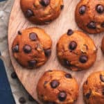 overhead view of pumpkin cookies on a wood cutting boarrd