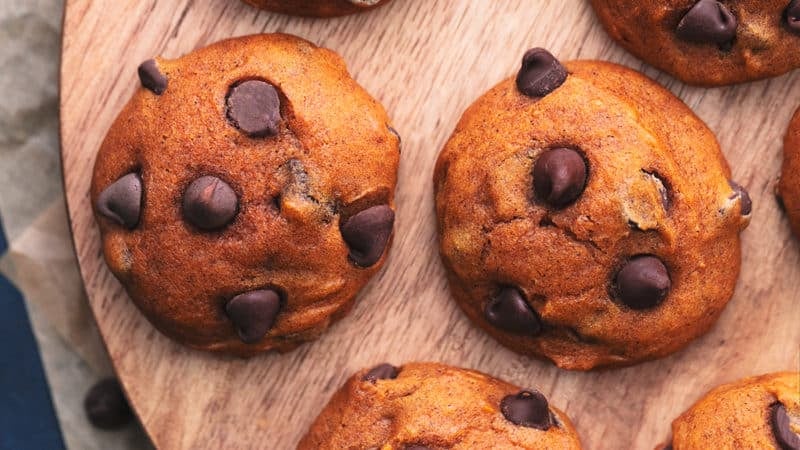 overhead view of pumpkin cookies on a wood cutting boarrd