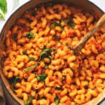 baked feta tomato pasta in pot with wooden serving spoon