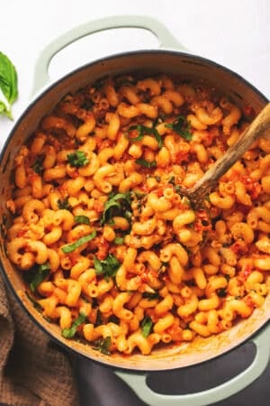 baked feta tomato pasta in pot with wooden serving spoon