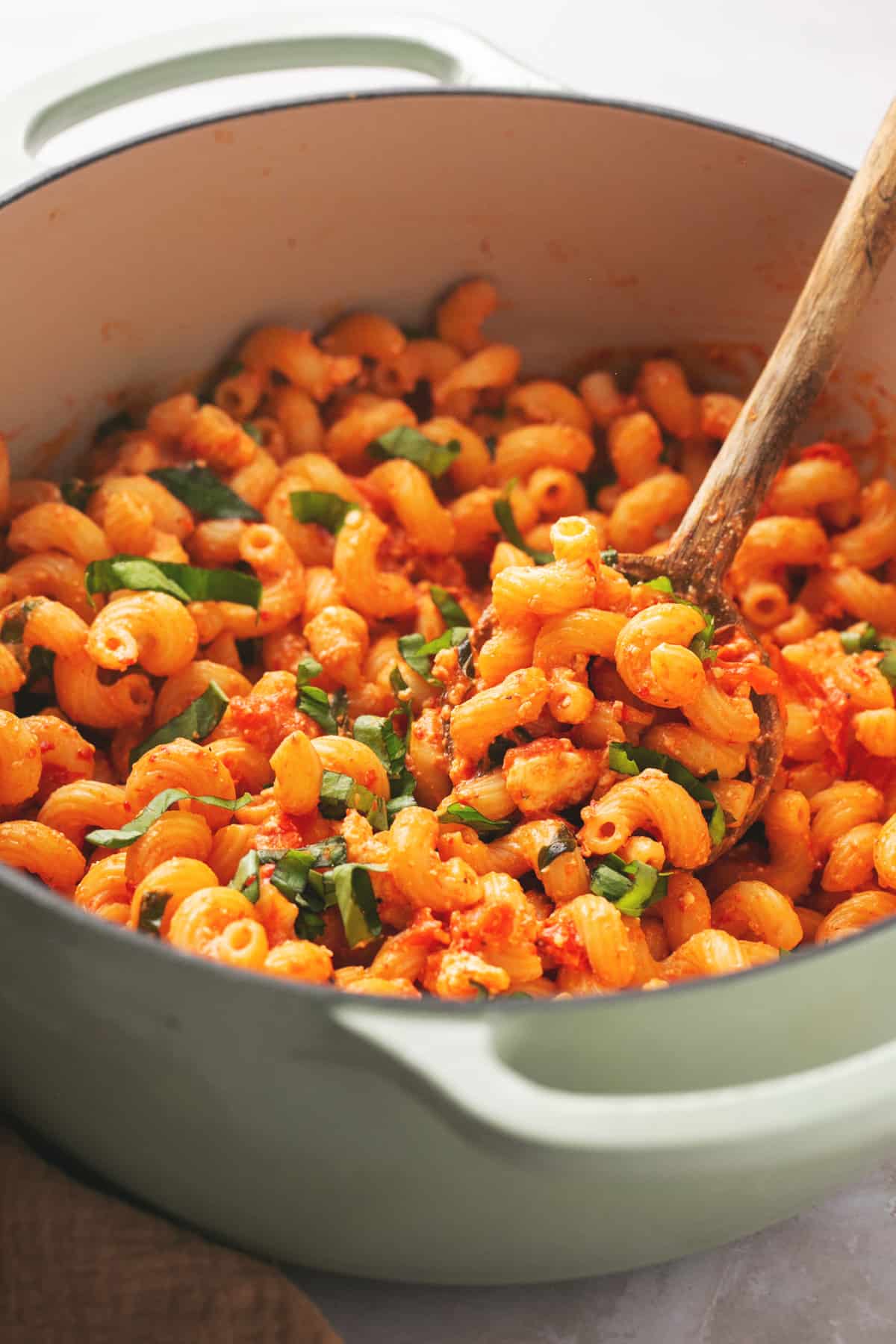 pot of tomato feta pasta with wooden serving spoon