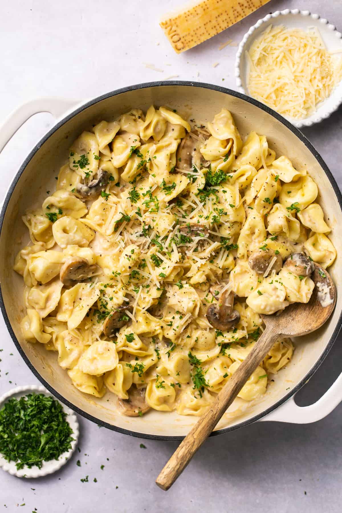 skillet of tortellini pasta with toppings surrounding