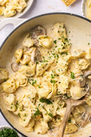 tortellini pasta with mushrooms and parsley in skillet