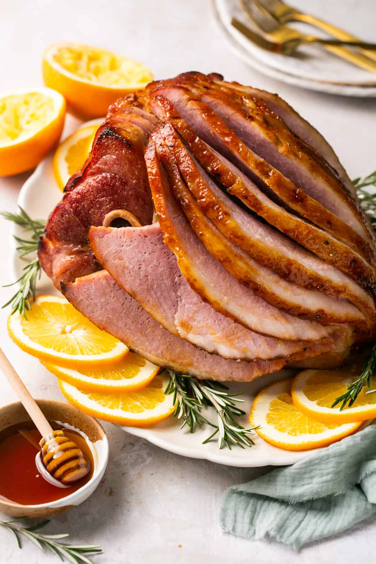 platter of glazed, baked ham on platter with garnishes