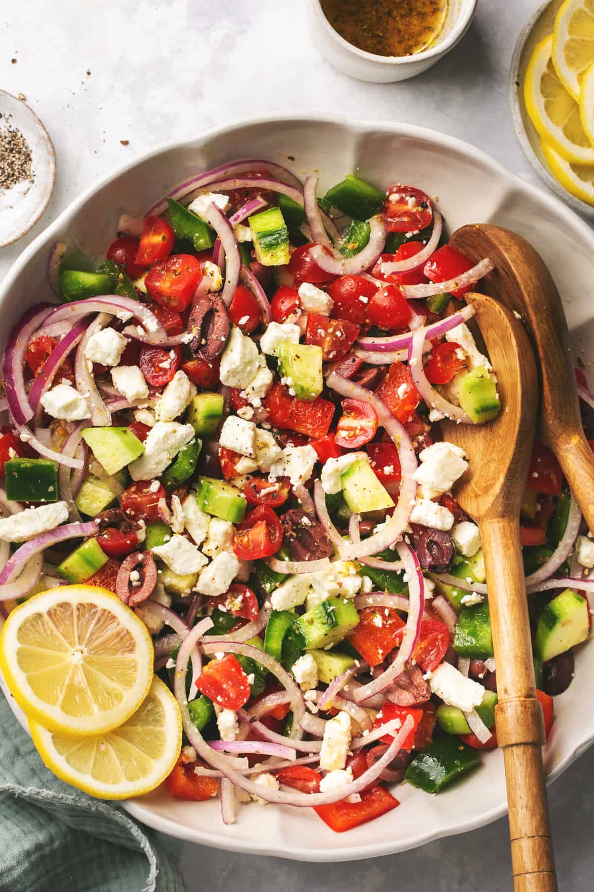 greek salad with tomatoes, onions, and cucumbers in a bowl