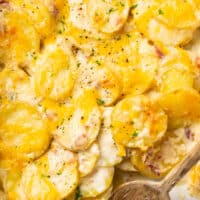 potatoes with cheese in baking dish with serving spoon