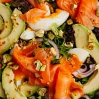 close up of smoked salmon and avocado on salad