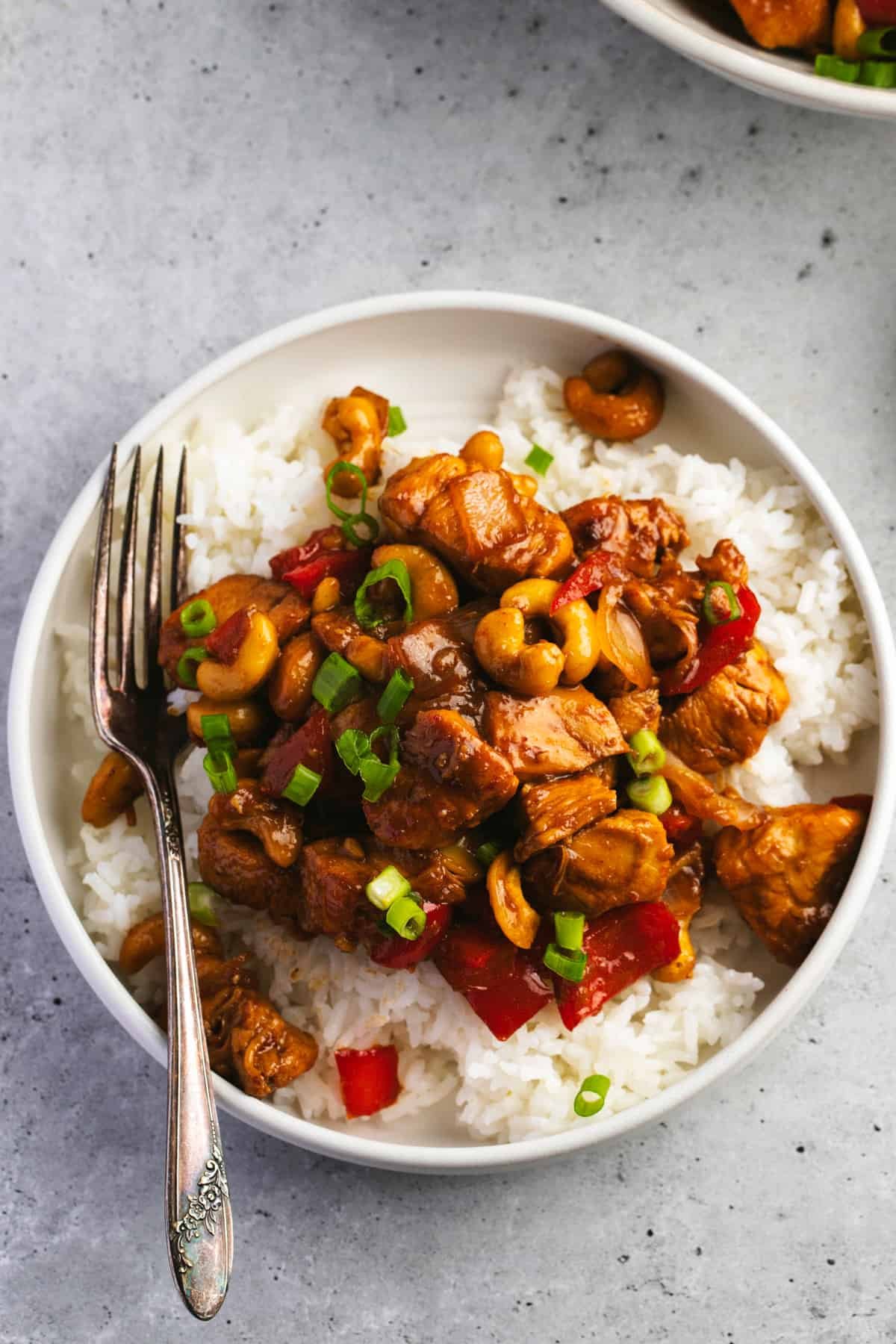 cashew chicken on white rice with fork on plate
