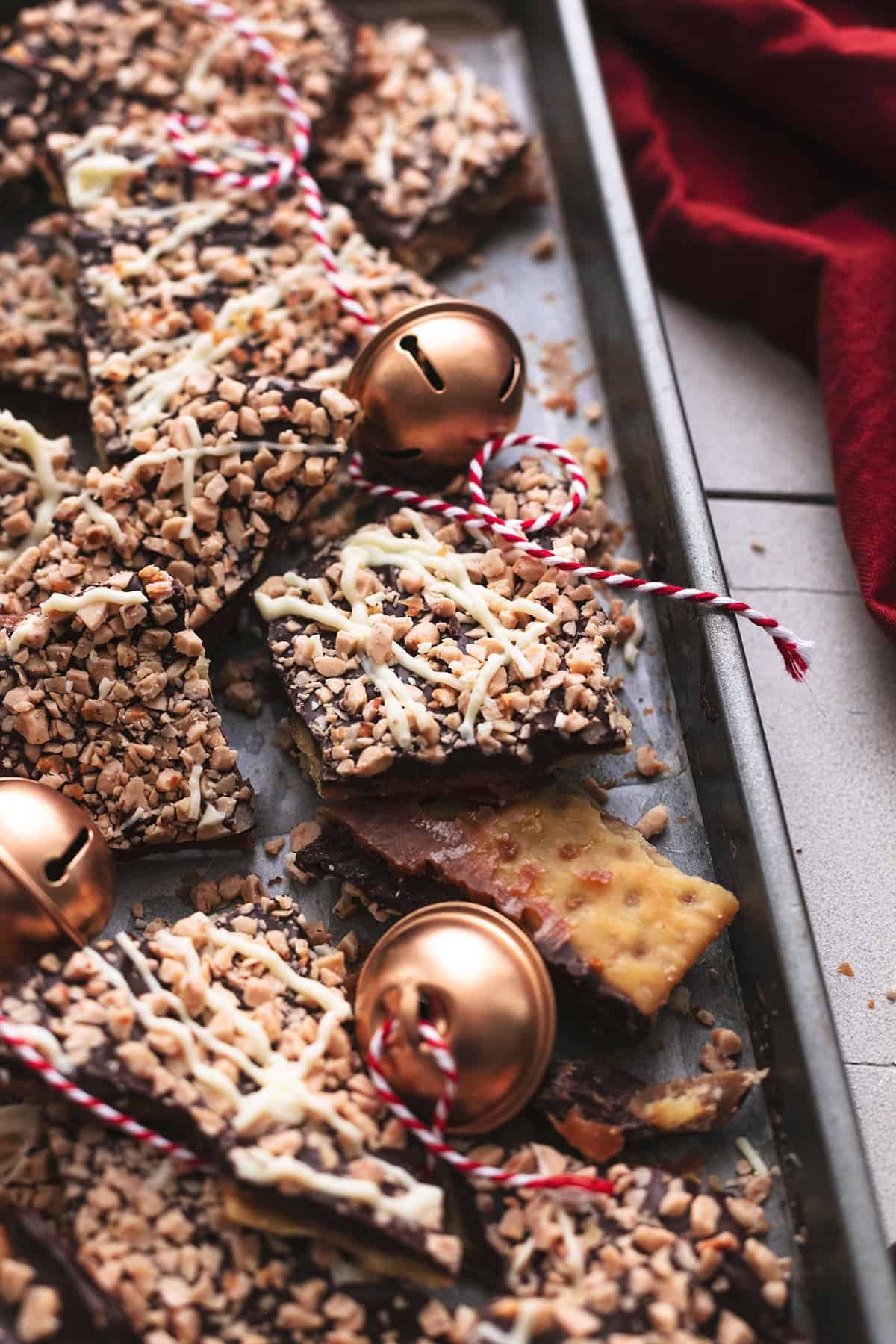 christmas crack pieces on a sheet pan with jingle bells