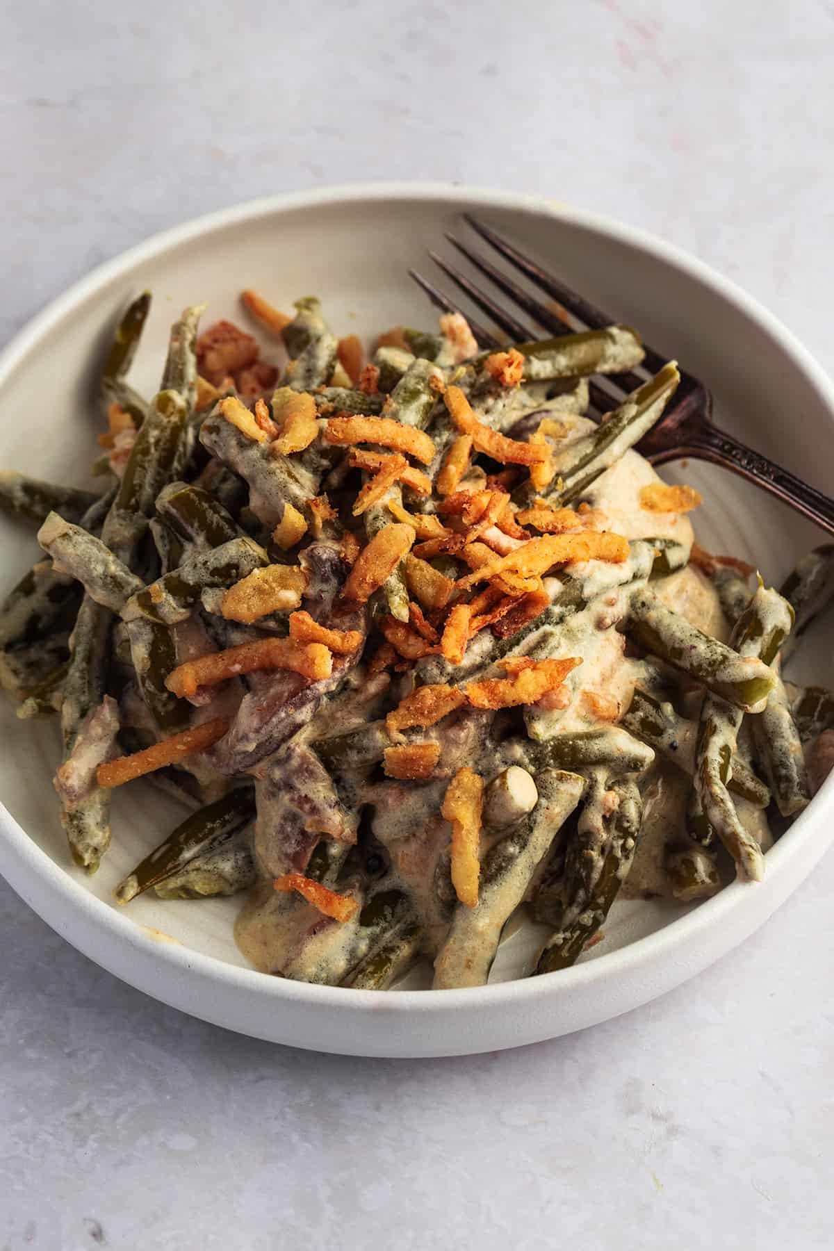 slow cooker green bean casserole on a plate with a fork