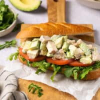 chicken salad on sub roll on a wooden cutting board