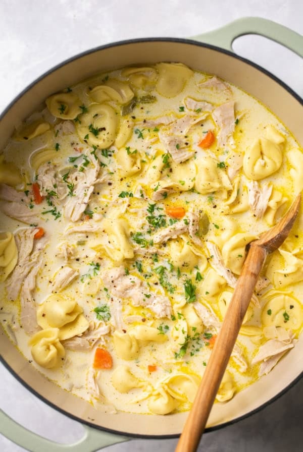 pot of soup with shredded chicken and tortellini noodles