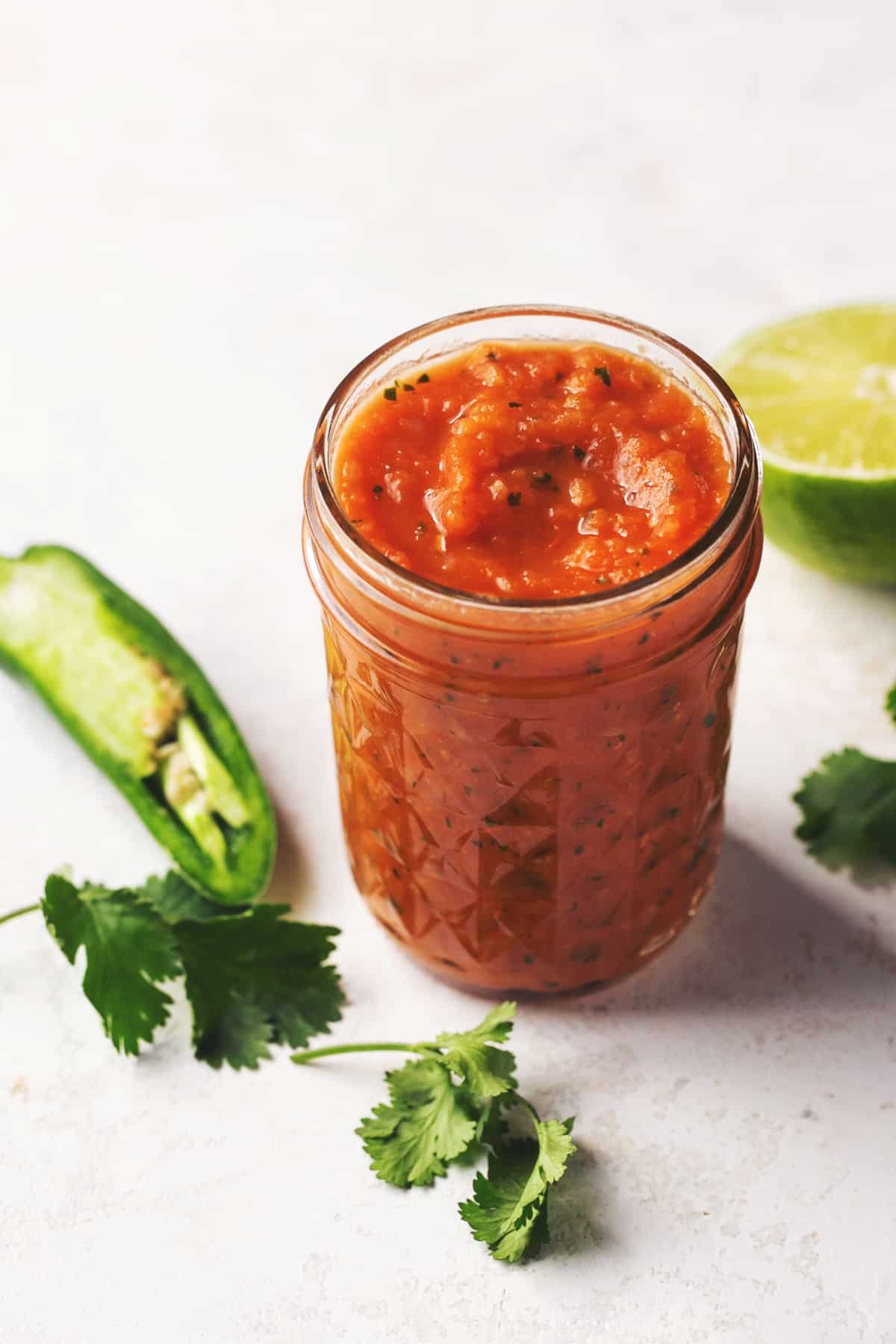 jar of canning salsa with jalapenos and limes