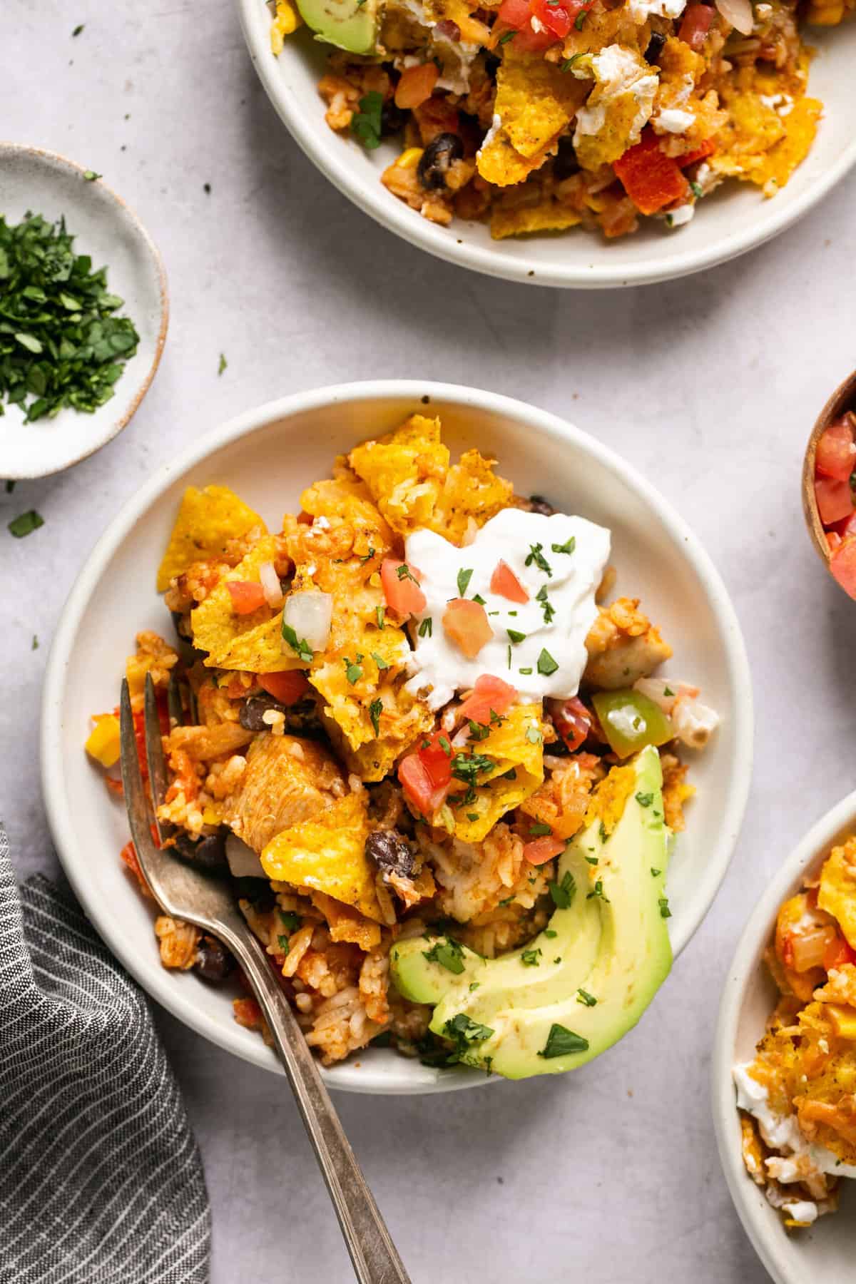 bowls of taco casserole with toppings and condiments in pinch bowls