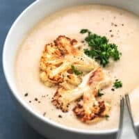 cauliflower soup in a bowl with spoon