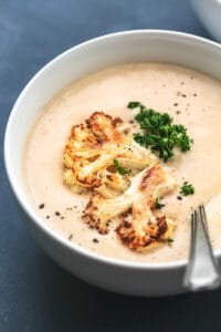 cauliflower soup in a bowl with spoon