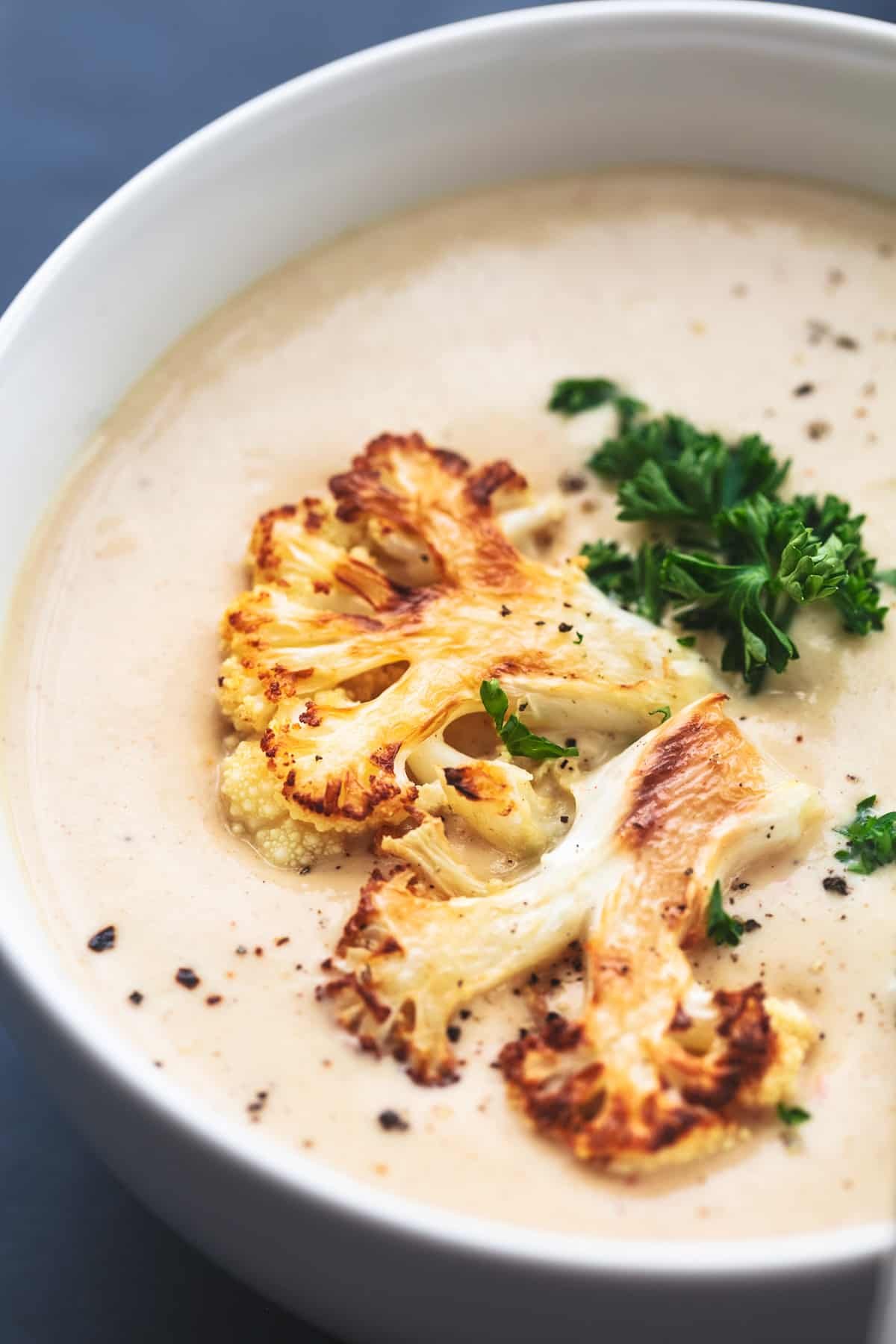 up close view of roasted cauliflower on top of soup in bowl