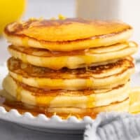 up close stack of pancakes with syrup dripping