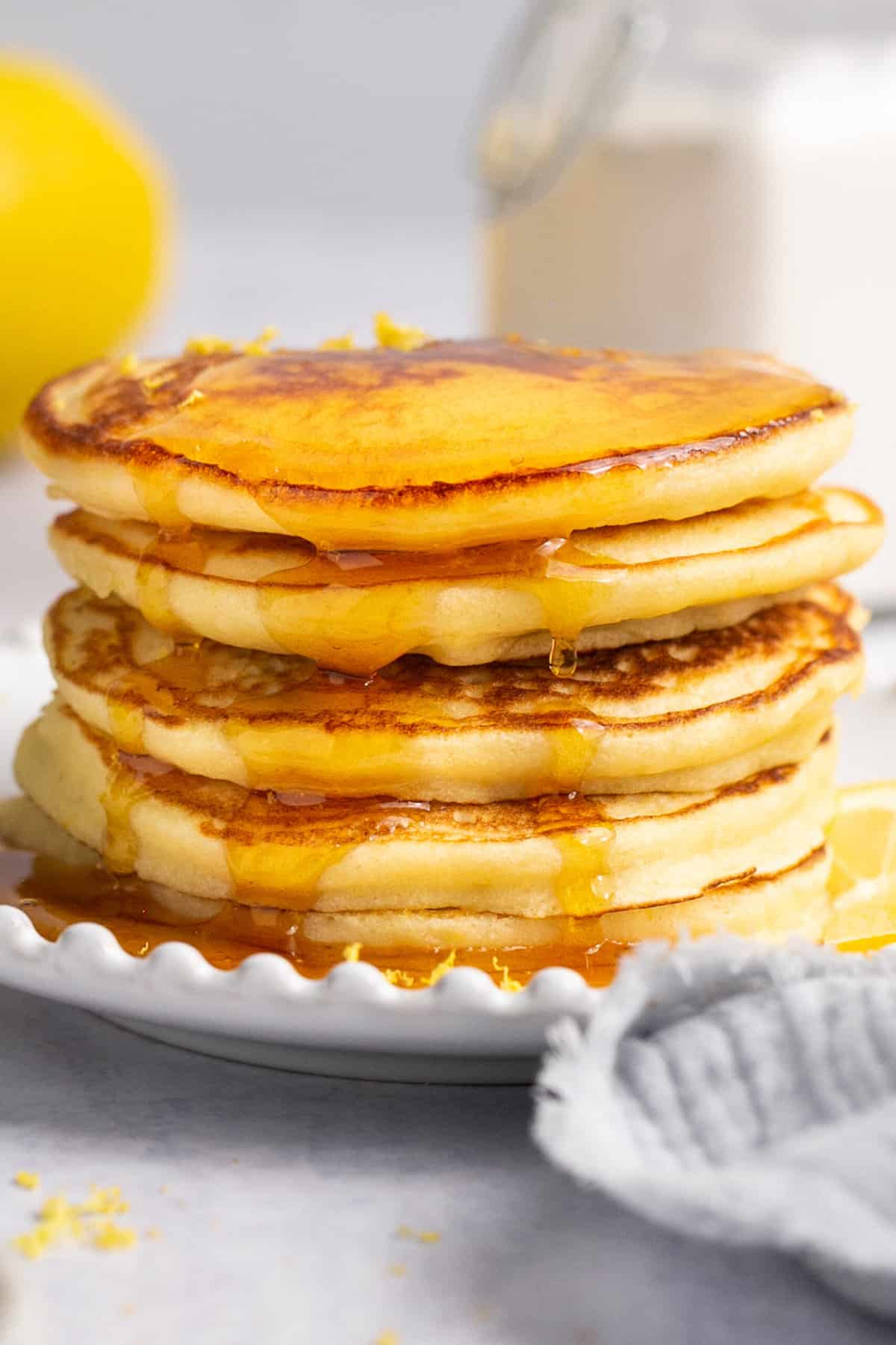 up close stack of pancakes with syrup dripping