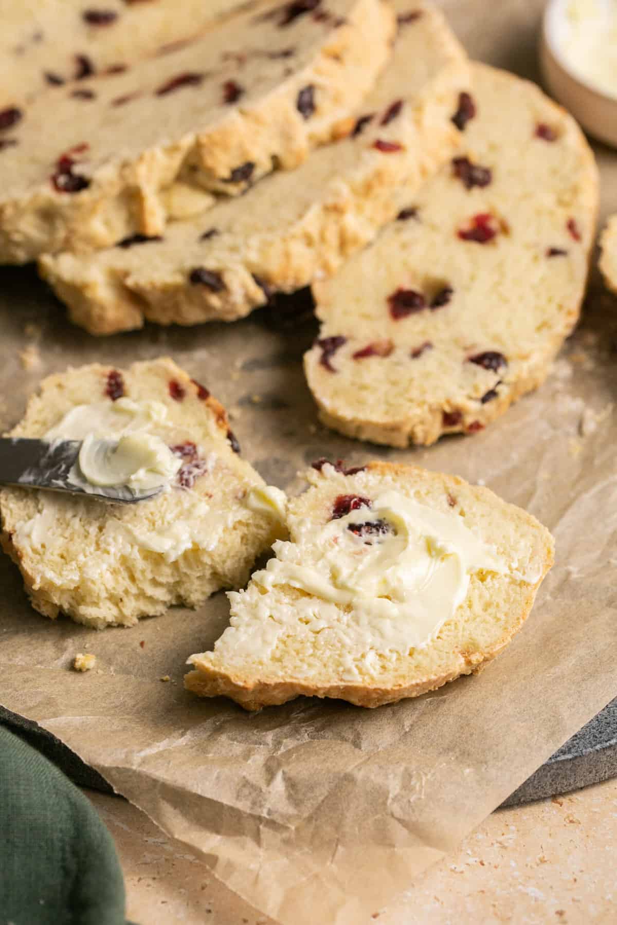 knife spreading butter onto slice of soda bread