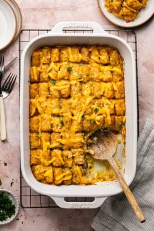 wooden spoon scooping tater tot casserole