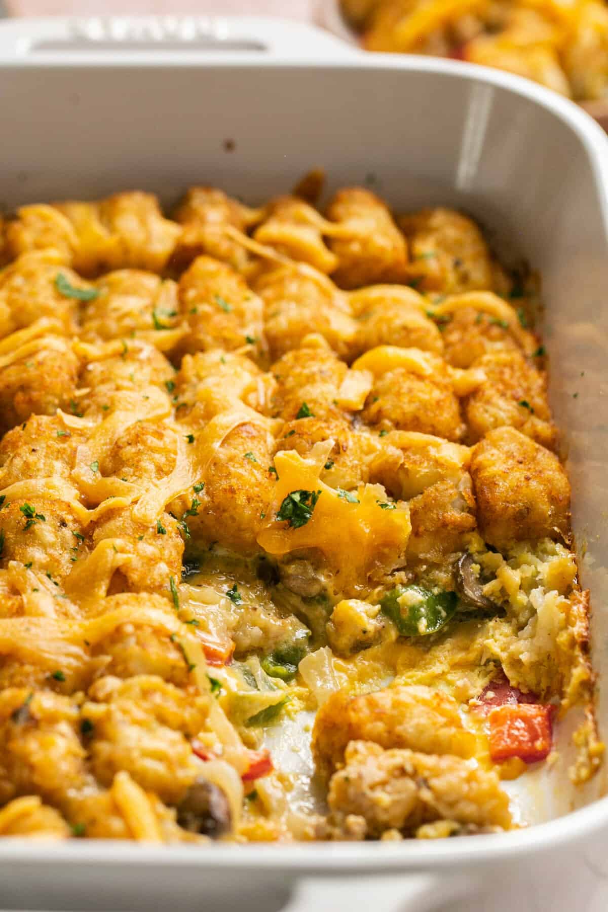 cheesy tater tots with sausage and vegetables in baking dish