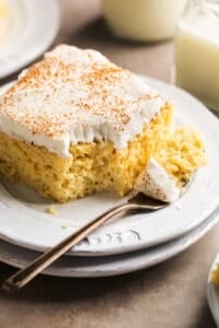 single bite of cake on fork on stacked plates