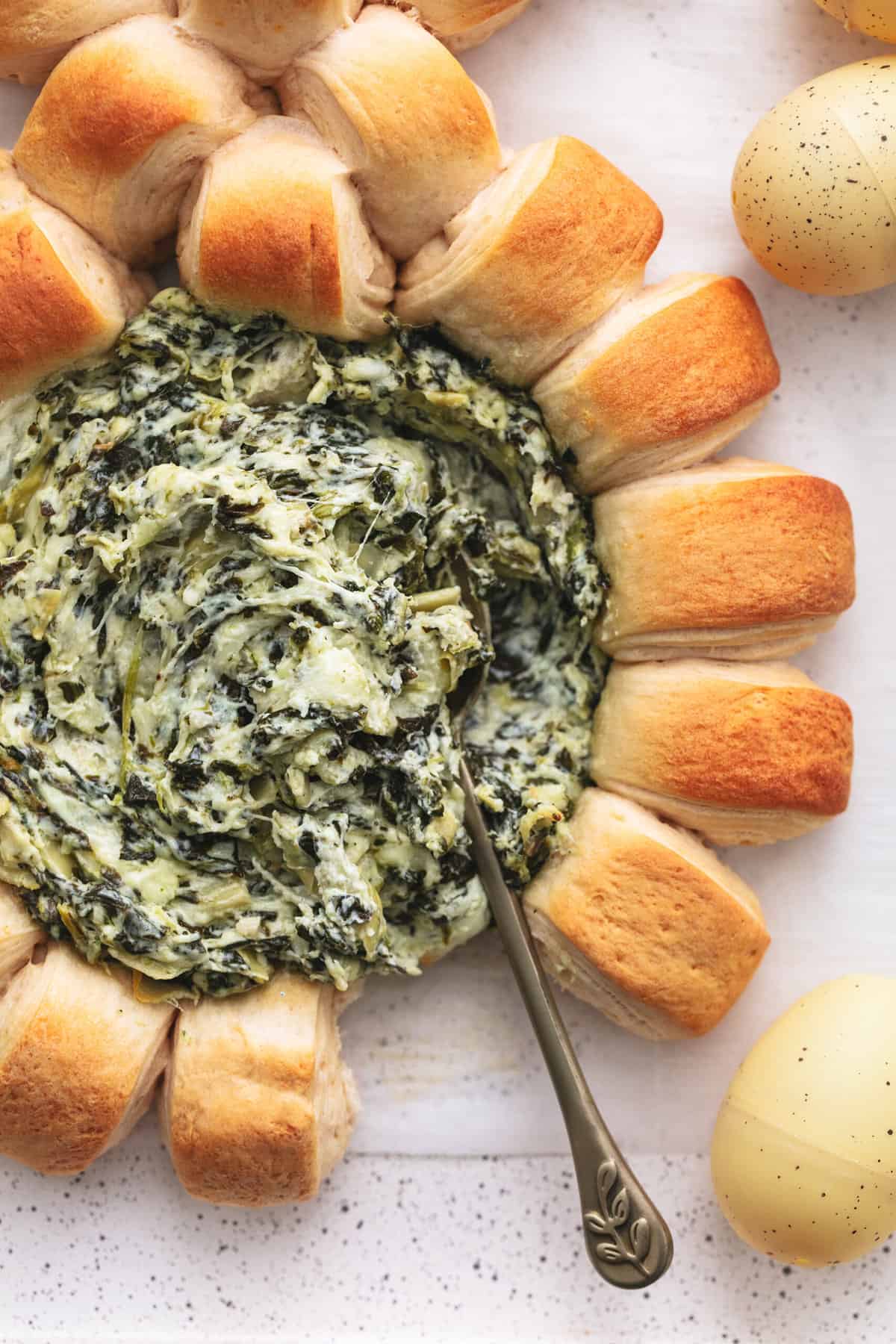 spinach dip with rolls and spoon