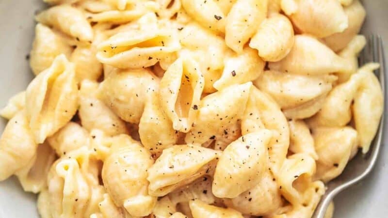 bowl of pasta shells with creamy cheese sauce with spoon